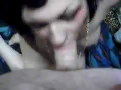 A dark brown, emo freak with pierced lips joyfully consuming a pecker